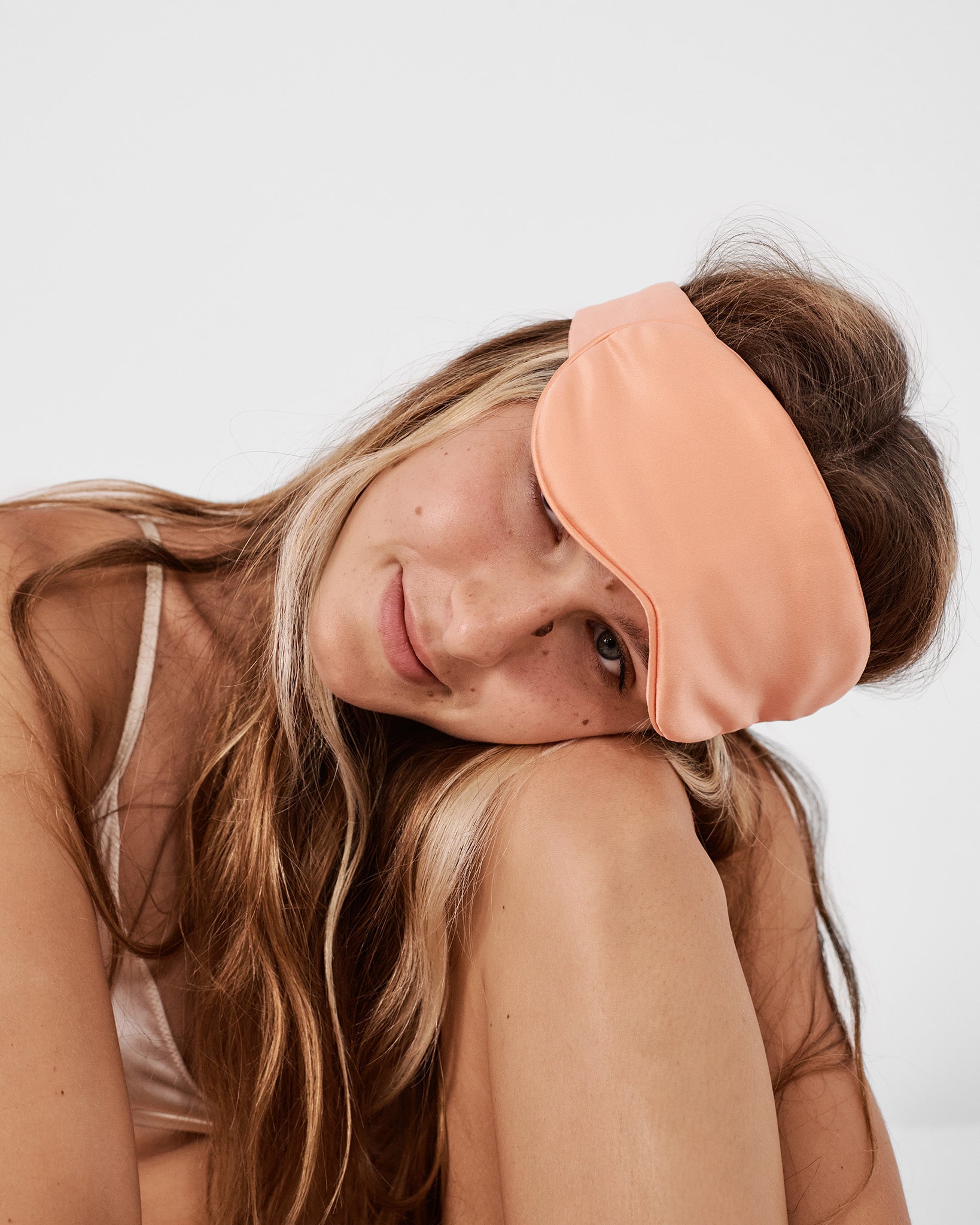 model with silk sleep mask in peach